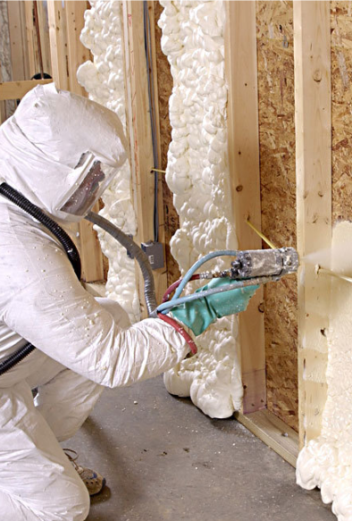 Expert installing spray foam insulation in walls.